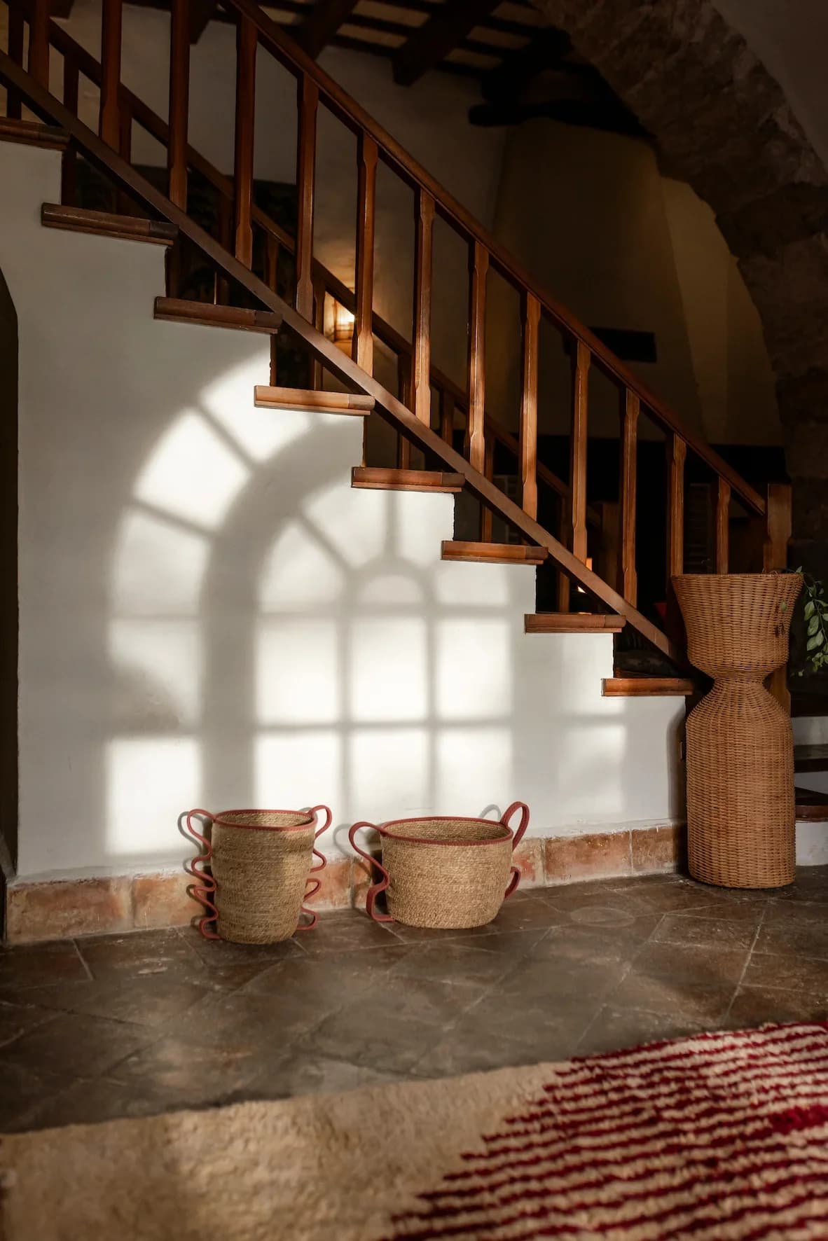 Wooden staircase and wicker baskets inside the Masia Can Pares guest houses